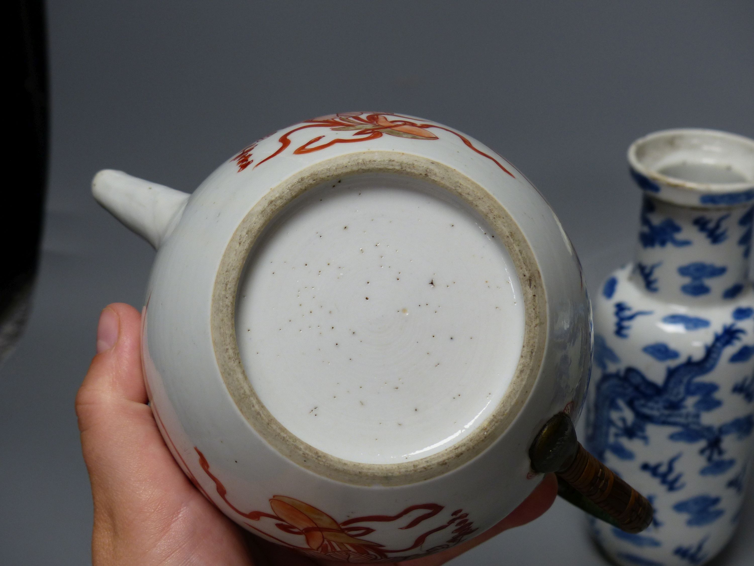 A 19th century Chinese blue and white covered jug, an early 20th century blue and white vase and a Kangxi rouge de fer teapot, tallest 18cm